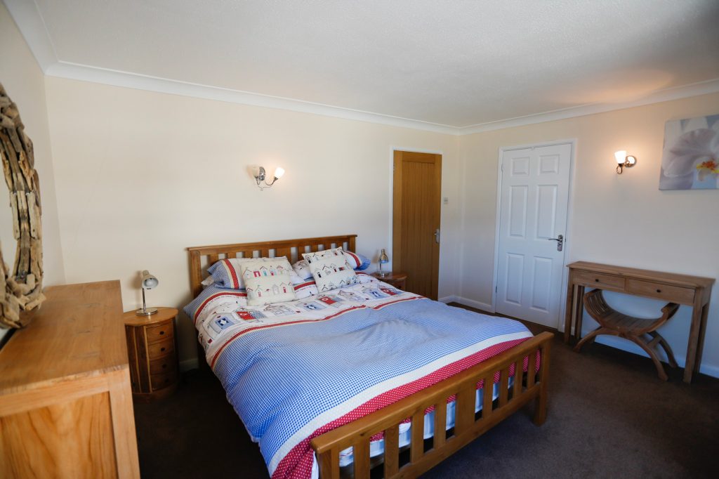Master Bedroom, double bed with 2 bedside tables. Towels neatly folded on top of bed ready for guests