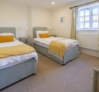 Twin room at Shalfleet Barn, two single beds with bed side tables and wardrobe/drawer space